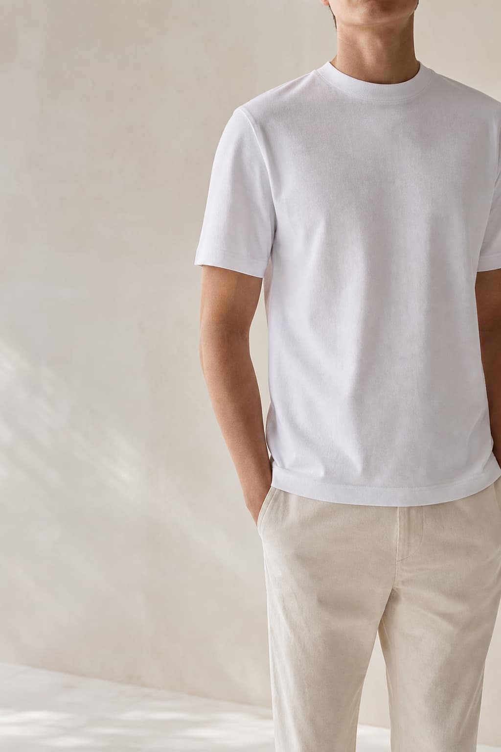 Core Tee in white, worn in an editorial studio setting
